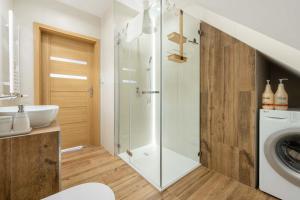 a bathroom with a sink and a washing machine at Apartamenty Słoneczne Tarasy z widokiem na góry - Dream Apart in Szczyrk +40 photos