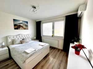 a bedroom with a white bed and a window at Large 75 m2 Apartment next to Airport - Free Parking in Prievoz