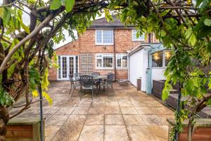 a patio with a table and chairs in front of a building at Stunning Large Modern House - 3 Car Driveway - En-suite Master Bedroom - PS4 & Table Football in Leicester +27 photos
