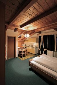 ein Schlafzimmer mit einem Bett und einem Tisch sowie eine Küche in der Unterkunft Residence Baumgartner in Völs am Schlern