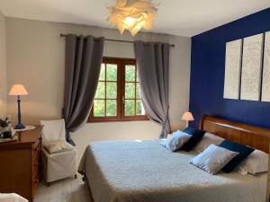 ein Schlafzimmer mit einem Bett mit blauen Wänden und einem Fenster in der Unterkunft Charme au cœur des Châteaux de la Loire avec Wifi - FR-1-590-305 in Tavers