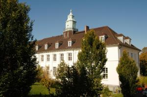 ein großes weißes Gebäude mit einem Turm darüber in der Unterkunft ABC Hotel in Konstanz