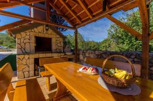 a wooden table with a basket of fruit on a patio at Villa Strikina kuca in Slivno