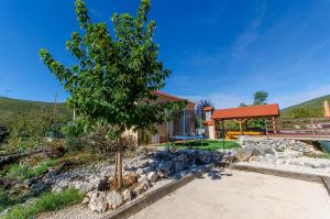 a house with a tree in front of a building at Villa Strikina kuca in Slivno