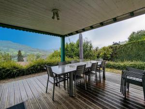 a wooden deck with a table and chairs on it at Chalet cosy avec spa et sauna, animaux admis - FR-1-589-673 in Fresse-sur-Moselle
