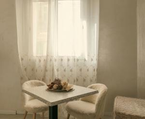 a table with two chairs and a plate of fruit on it at Sliema Central Iprime Suites in Sliema