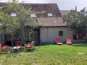 a group of chairs and tables in front of a house at Maison individuelle près de la Châtre, jardin privé, jacuzzi - FR-1-591-629 in La Berthenoux