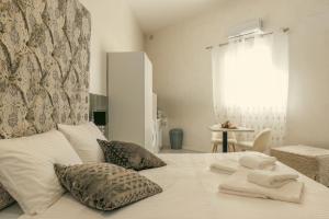 a bedroom with a bed with white sheets and pillows at Sliema Central Iprime Suites in Sliema