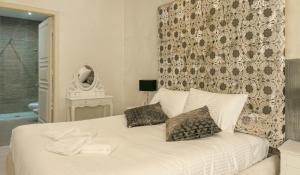 a white bed with two pillows in a bedroom at Sliema Central Iprime Suites in Sliema