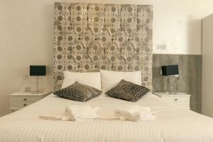 a white bed with two pillows on top of it at Sliema Central Iprime Suites in Sliema