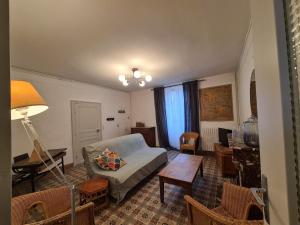 un soggiorno con un divano e un tavolo di Maison de ville conviviale avec jardin proche d'Argenton-sur-Creuse - FR-1-591-628 a Saint-Marcel