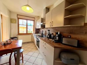 a kitchen with white cabinets and a wooden counter top at Bel appart au centre avec terrasse et parking - FR-1-589-674 in Gérardmer +6 photos