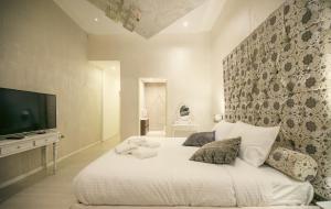 a bedroom with a large white bed with a flat screen tv at Sliema Central Iprime Suites in Sliema