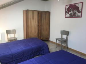 a bedroom with a bed and two chairs and a cabinet at Gîte en Lorraine : 3 ch, jardin, proche Lac de Madine - FR-1-584-335 in Saint-Baussant