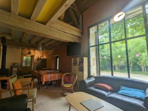 a living room with a blue couch and a table at Grange éco-rénovée au cœur de la nature - FR-1-591-633 in Pouligny-Saint-Pierre