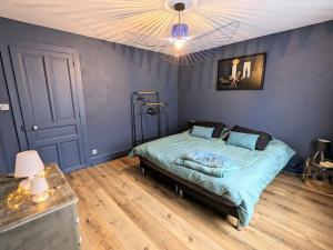 a bedroom with a bed with blue walls and a ceiling at Appartement rénové avec jardin, parking et WiFi à Gérardmer - FR-1-589-678 in Gérardmer