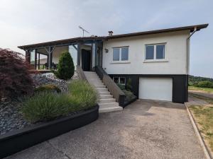 a white house with a driveway and a garage at Maison spacieuse avec spa, animaux acceptés, près d'Épinal - FR-1-589-680 in Dounoux