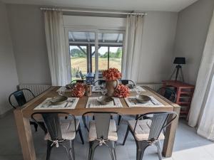 a dining room table with chairs and a large window at Maison spacieuse avec spa, animaux acceptés, près d'Épinal - FR-1-589-680 in Dounoux