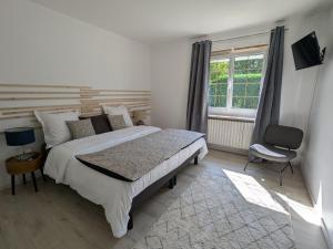 ein Schlafzimmer mit einem Bett und einem Stuhl und einem Fenster in der Unterkunft Maison spacieuse avec jardin privé et WIFI, proche Épinal - FR-1-589-681 in Dinozé