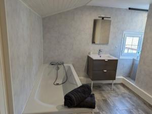 ein Badezimmer mit Badewanne und Waschbecken in der Unterkunft Maison spacieuse avec jardin privé et WIFI, proche Épinal - FR-1-589-681 in Dinozé + 11 Fotos