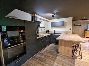 a kitchen with black cabinets and a wooden counter at Chalet de charme pour 6 pers., proche ski, WiFi, parking, animaux admis - FR-1-589-683 in Cornimont +27 photos
