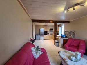 ein Wohnzimmer mit einem lila Sofa und einer Küche in der Unterkunft Maison en Berry avec jardin clos près du lac d'Eguzon - FR-1-591-651 in Orsennes