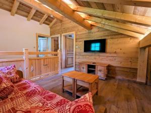 ein Wohnzimmer mit Sofa und Fernseher in der Unterkunft Chalet au cœur des Vosges avec sauna, terrasse et connexion WIFI - FR-1-589-692 in Cornimont