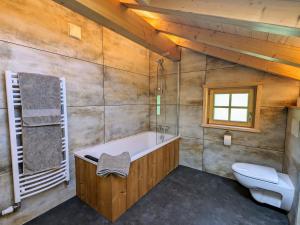 ein Badezimmer mit Badewanne und Toilette in der Unterkunft Chalet au cœur des Vosges avec sauna, terrasse et connexion WIFI - FR-1-589-692 in Cornimont + 27 Fotos