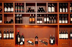 a row of wine bottles sitting on top of a wooden shelf at Vienna House Thüringer Hof Eisenach in Eisenach