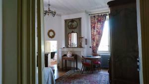 a room with a fireplace and a table and a mirror at Chateau de Durianne in Le Monteil