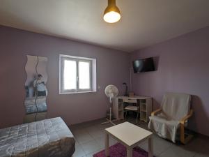 a bedroom with a bed and a table and a window at Maison spacieuse et contemporaine avec parking, vélos et baby-foot en Berry - FR-1-591-649 in Neuvy-Saint-Sépulchre