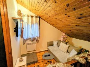 a living room with a couch and a wooden ceiling at Chalet familial Vosges avec baby-foot et animaux admis - FR-1-589-688 in Ventron