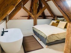 a bedroom with a bed and a bath tub in a attic at Loft moderne au charme ancien, climatisé, près de la Place Stanislas - FR-1-584-352 in Nancy
