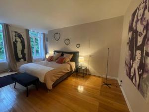 Schlafzimmer mit einem Kingsize-Bett und Holzböden in der Unterkunft Appartement bourgeois et moderne au cœur d'Épinal, idéal pour découvrir la ville - FR-1-589-691 in Épinal