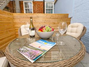 una mesa de mimbre con un bol de frutas y copas de vino en Two No36, en Weymouth