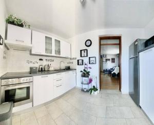 SkrbčićiにあるLovely Apartment Marina Blueの白いキャビネットとコンロ付きオーブンを備えたキッチン