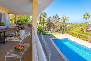 patio z basenem, stołem i krzesłami w obiekcie Villa Berry w miejscowości Santa Ponsa