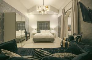 a bedroom with a bed and a couch and a mirror at Sliema Central Iprime Suites in Sliema