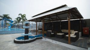 a pavilion with a water fountain next to a pool at Royal Twin Lonavla - 12BHK Luxury Villa with Turf in Lonavala