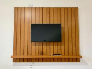 a flat screen tv on top of a wooden wall at Apartamento aconchegante no Centro de Peruibe in Peruíbe