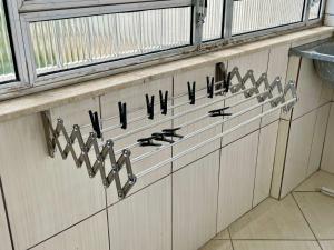 a row of utensils hanging on a wall at Apartamento aconchegante no Centro de Peruibe in Peruíbe