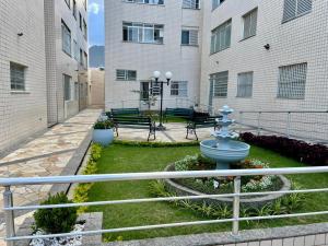 a courtyard with benches and a fountain in front of a building at Apartamento aconchegante no Centro de Peruibe in Peruíbe