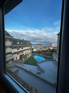 a view of a swimming pool from a window at Malpica beach in Malpica
