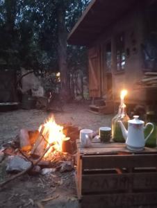 ein Lagerfeuer mit einem Tisch, einem Wasserkocher und einer Kerze in der Unterkunft Espacio Tierra in Punta Colorada