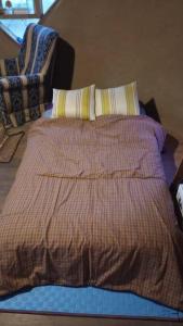 ein Bett mit einer Decke und zwei Kissen darauf in der Unterkunft Espacio Tierra in Punta Colorada