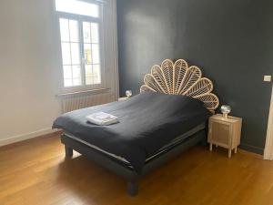 a bedroom with a bed with a large headboard at Maison de 140m2 à 300m de la plage in Dunkerque