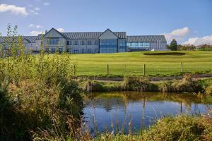 ダグラスにあるComis Hotel & Golf Resortの池のある大きな建物