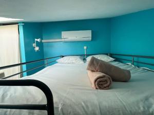 a blue bedroom with a bed with a towel on it at Villa Playa proche plage piscine climatisation parking in Palavas-les-Flots