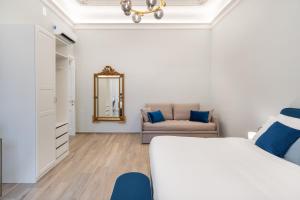 a white bedroom with a bed and a couch at Palazzo Galeoni Luxury Suites in Salerno