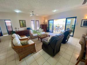 un salon avec des canapés, des chaises et une table dans l'établissement Willmett Street 3/19, à Townsville